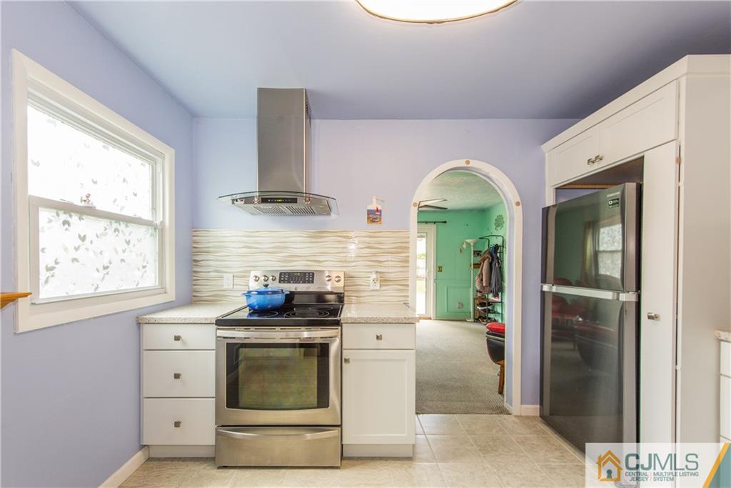 127 Idlewild Road Edison, NJ 08817 - Photo 8 of 21 a kitchen with stainless steel appliances granite countertop a stove a refrigerator and a microwave