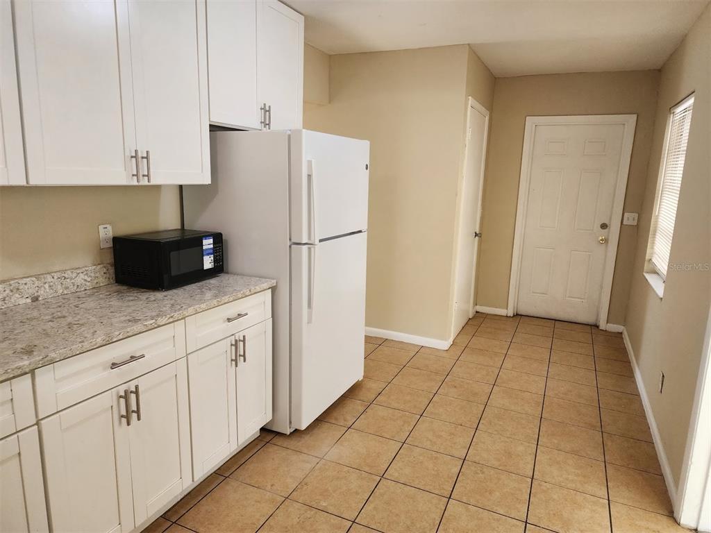 3904 West Walnut Street Tampa, FL 33607 - Photo 4 of 16 a kitchen with white cabinets and refrigerator