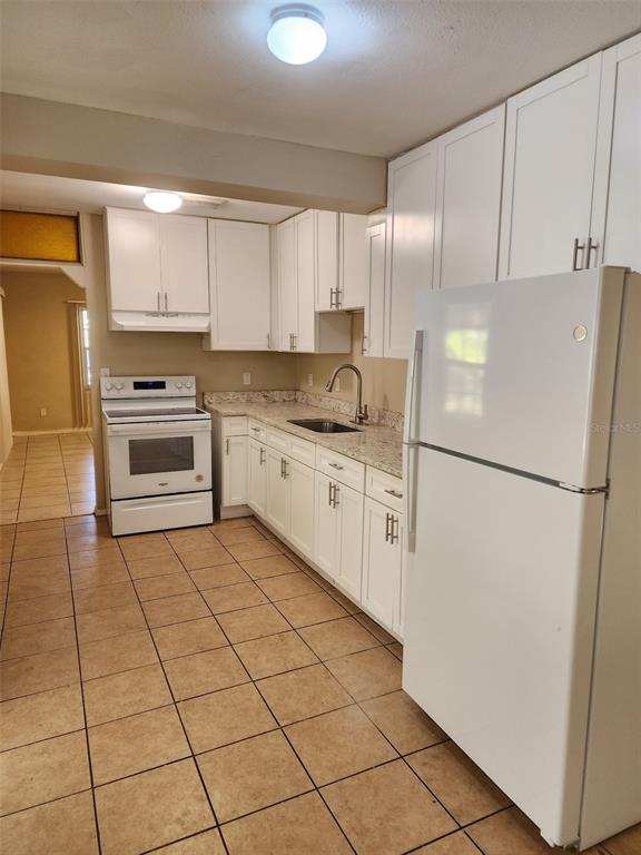 3904 West Walnut Street Tampa, FL 33607 - Photo 5 of 16 a kitchen with granite countertop a refrigerator and a sink