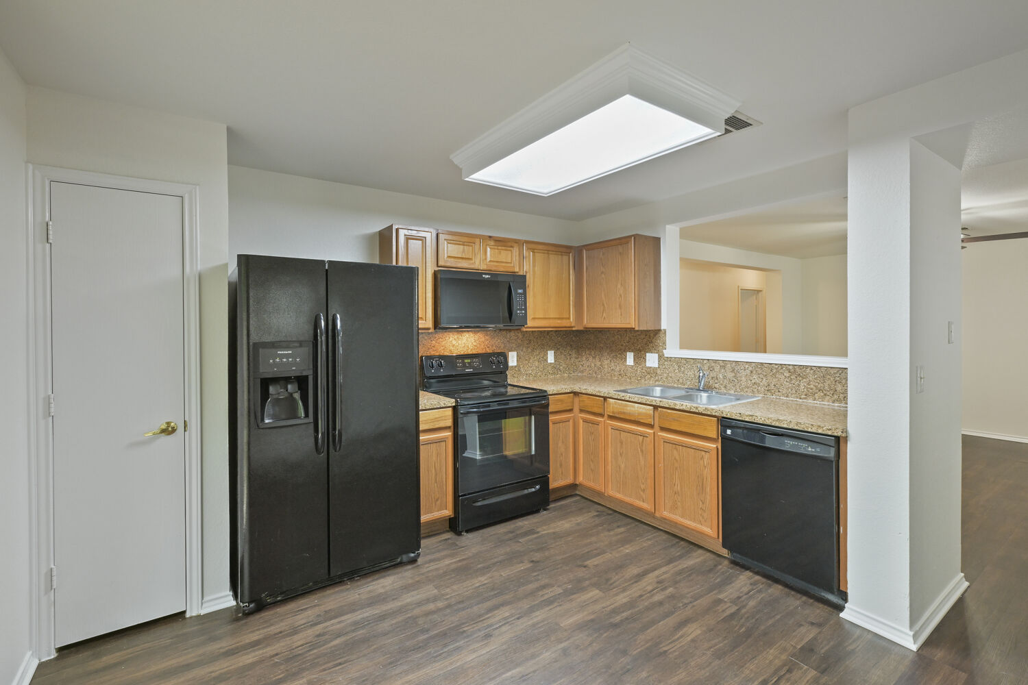 6733 Doyal Drive Austin, TX 78747 - Photo 19 of 28 Functional kitchen with warm wood cabinetry, granite-style countertops, and a convenient pass-through window.