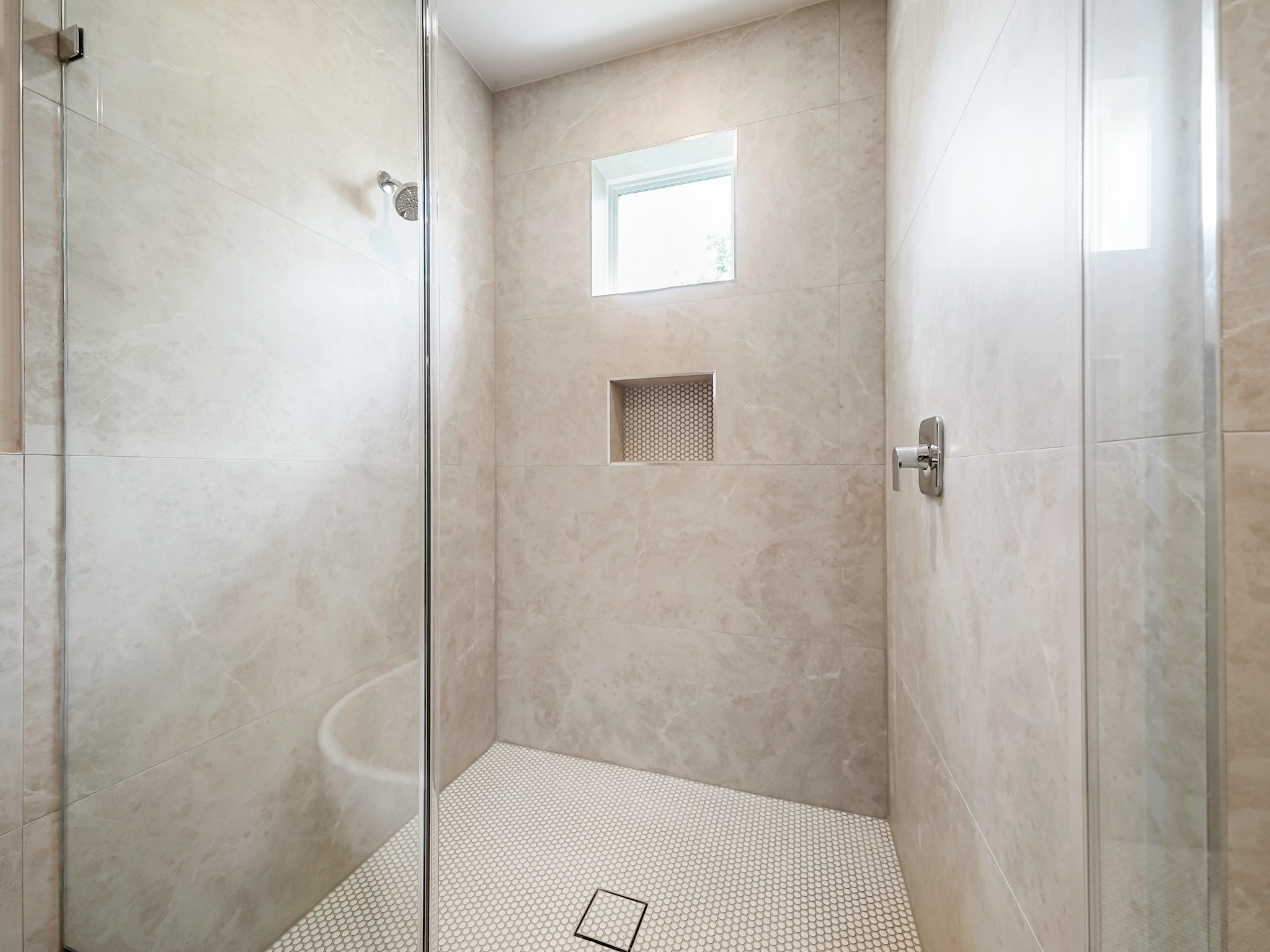 861 Rachel Street, Unit E Houston, TX 77091 - Photo 16 of 29 Experience luxury and space in this stunning walk-in shower, featuring sleek glass doors, elegant tile, and a modern niche for your essentials.