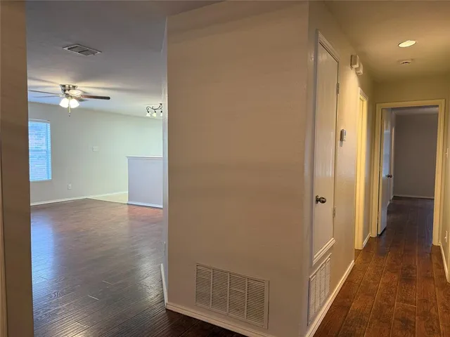a view of a hallway with wooden floor