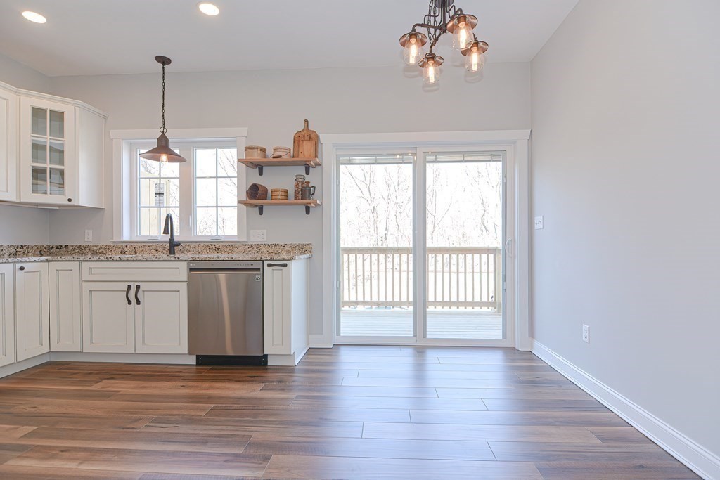 260 Main Street, Unit 3 Blackstone, MA 01504 - Photo 9 of 40 a kitchen with kitchen island granite countertop a stove a sink and dishwasher with wooden floor