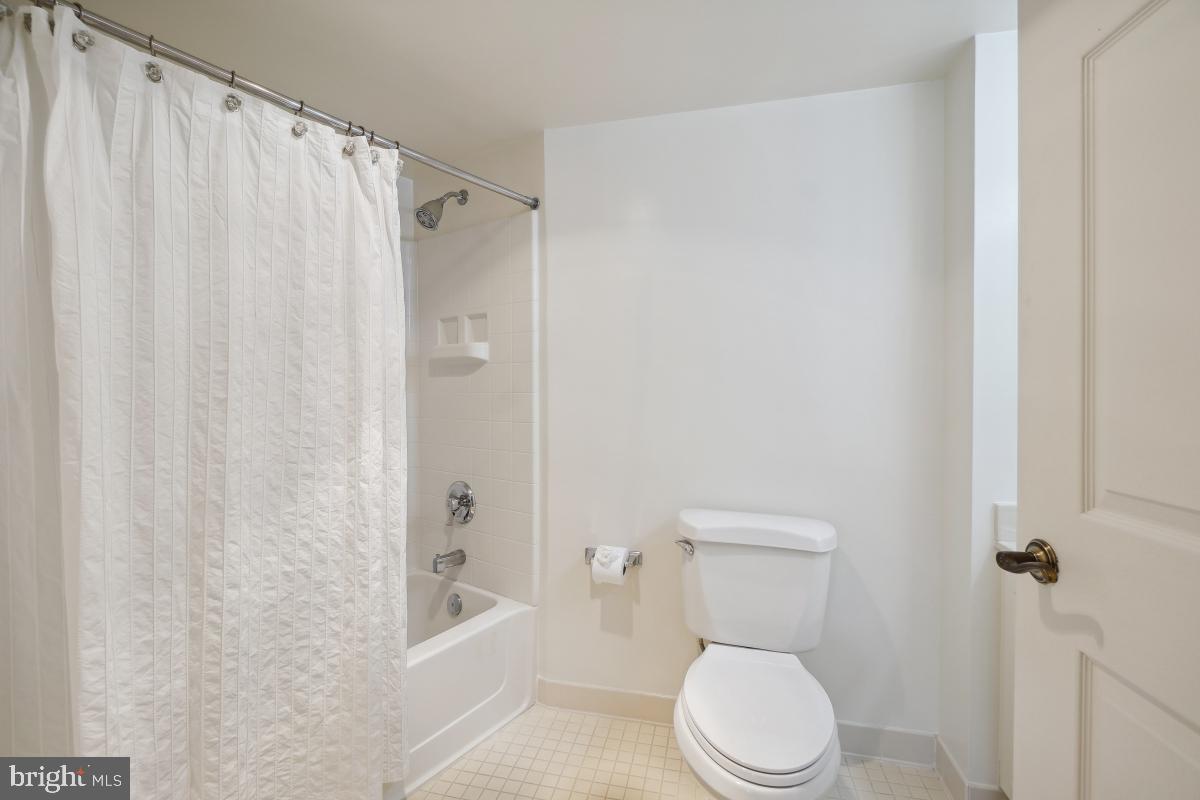 14801 Pennfield Circle, Unit 401 Silver Spring, MD 20906 - Photo 21 of 31 a bathroom with a toilet and a shower curtain