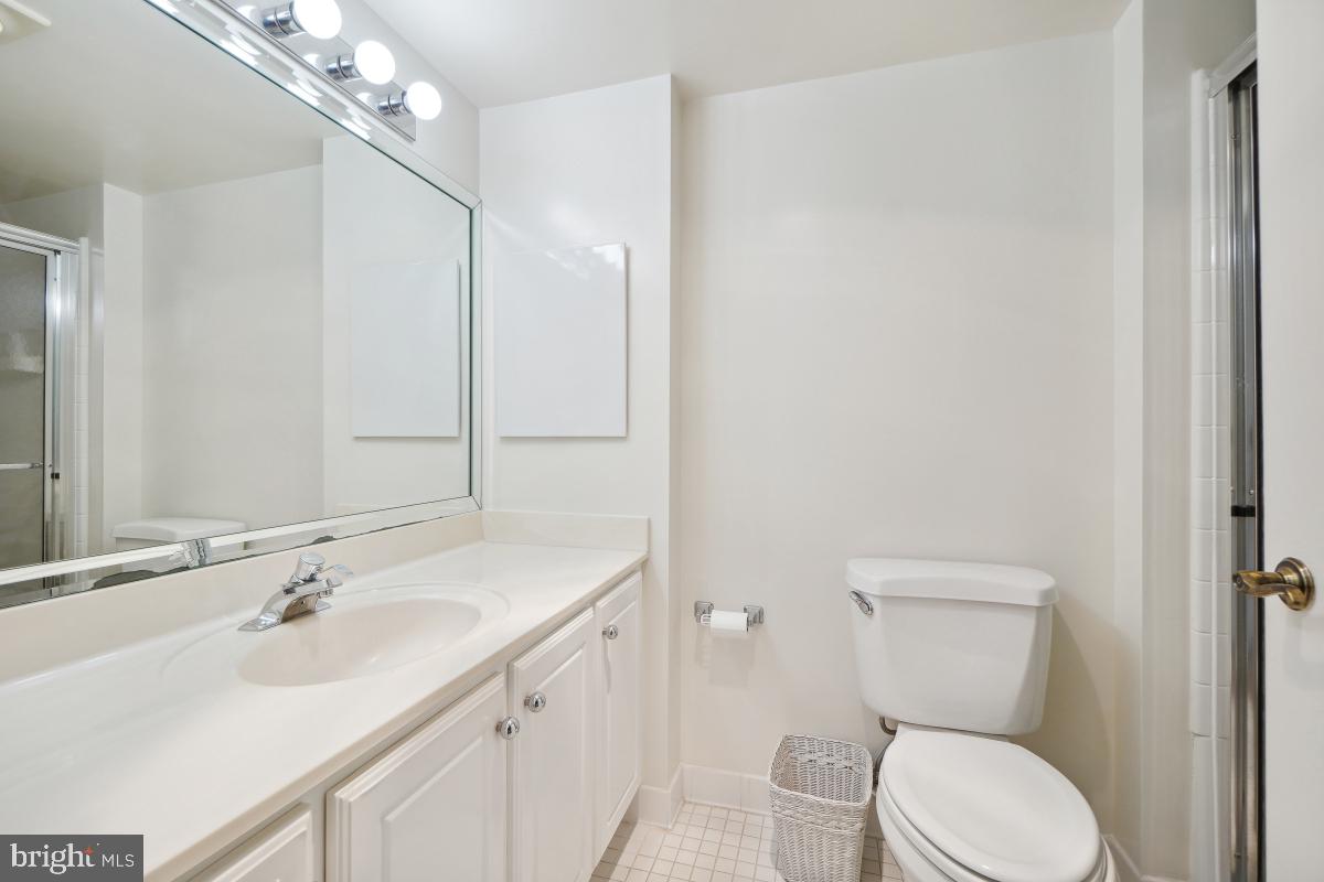 14801 Pennfield Circle, Unit 401 Silver Spring, MD 20906 - Photo 25 of 31 a bathroom with a toilet a sink a mirror and vanity