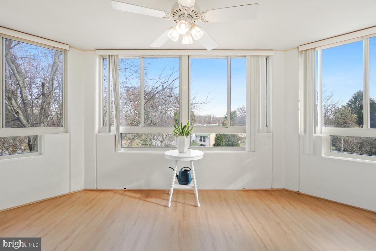 14801 Pennfield Circle, Unit 401 Silver Spring, MD 20906 - Photo 9 of 31 a view of an empty room with a window and wooden floor