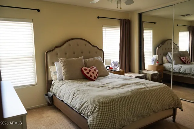 a bedroom with a bed and a mirror on dresser