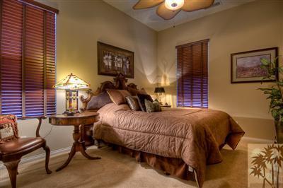 81249 Red Rock Road La Quinta, CA 92253 - Photo 16 of 25 a bedroom with a bed a lamp and paintings on the wall