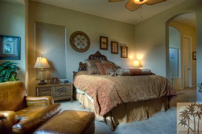 81249 Red Rock Road La Quinta, CA 92253 - Photo 20 of 25 a bedroom with a bed a mirror and a lamp on table