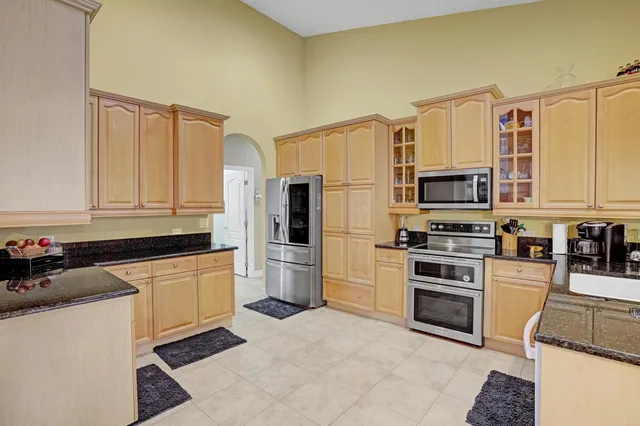 a kitchen with stainless steel appliances granite countertop a refrigerator and a stove top oven