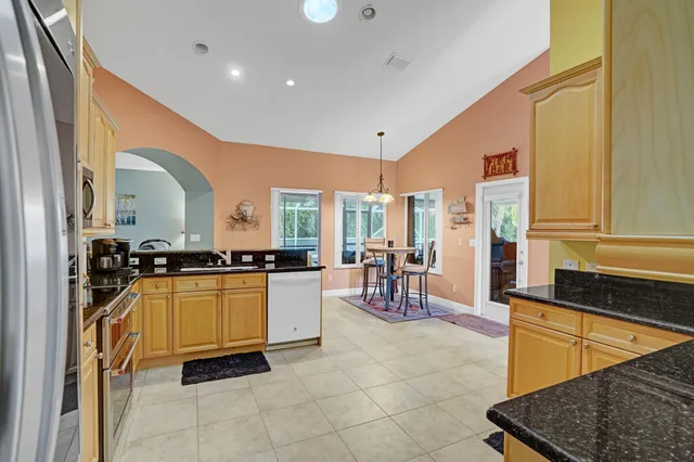 a kitchen with granite countertop a sink stainless steel appliances and cabinets
