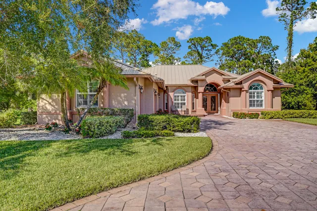 a front view of a house with a garden