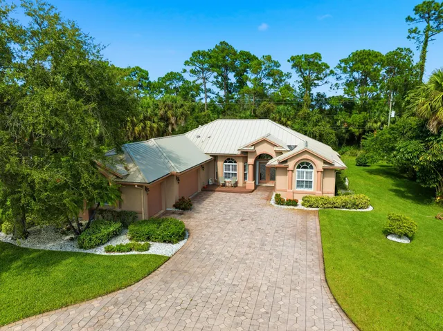 a aerial view of a house with a swimming pool a yard and potted plants