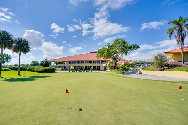 an aerial view of a residential houses with outdoor space and trees all around