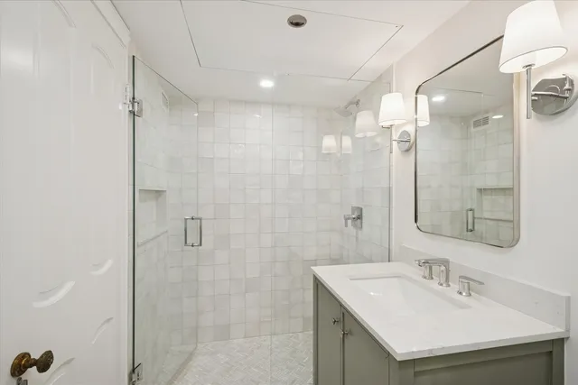 a bathroom with a sink shower and a mirror