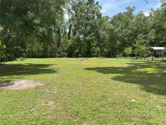 a view of a house with a yard and sitting area