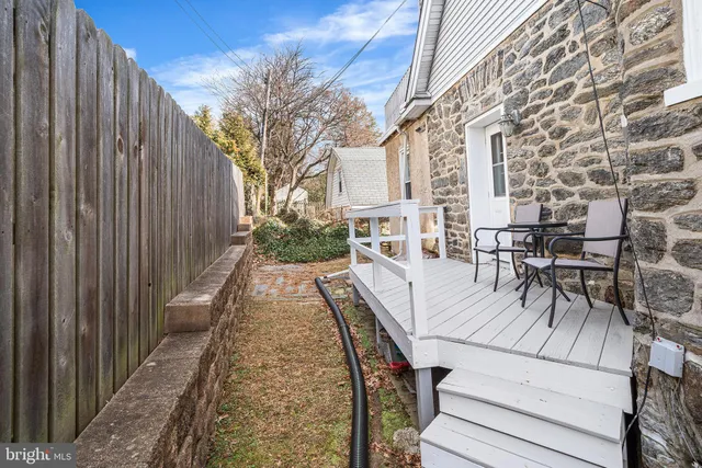 a view of a patio with table and chairs with wooden floor and fence