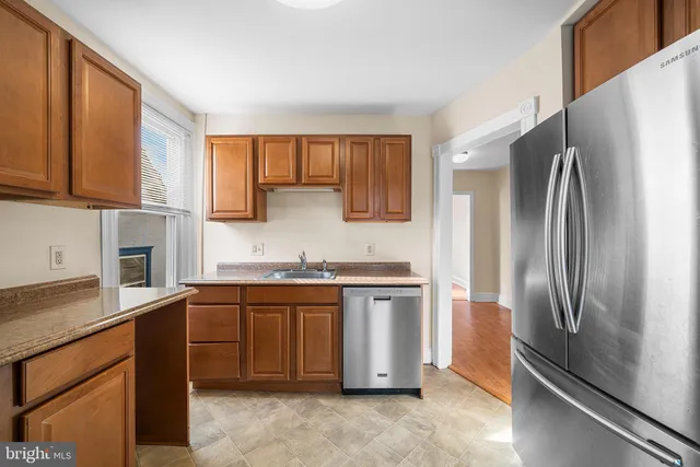 a kitchen with stainless steel appliances granite countertop a refrigerator sink and stove