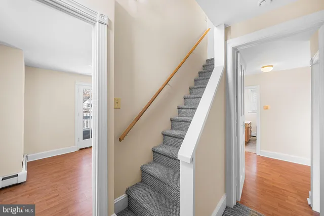 a view of staircase with wooden floor and white walls