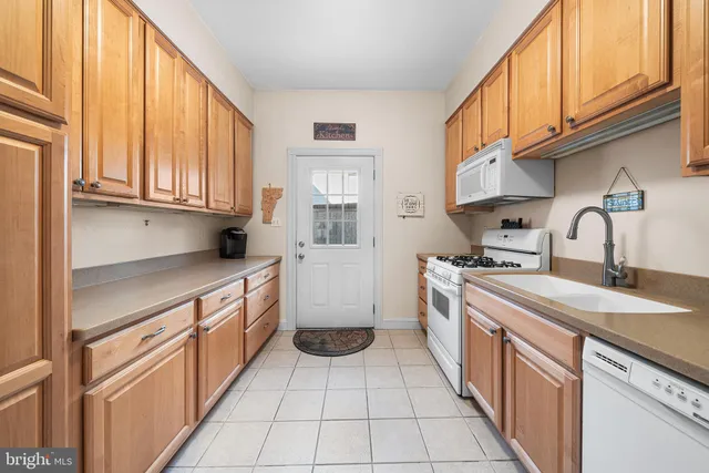 a kitchen with stainless steel appliances granite countertop a sink and dishwasher a stove with wooden cabinets