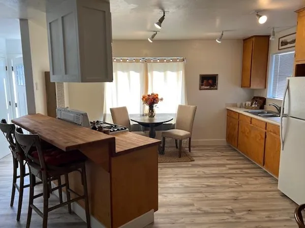 a kitchen with stainless steel appliances granite countertop a table chairs sink and cabinets