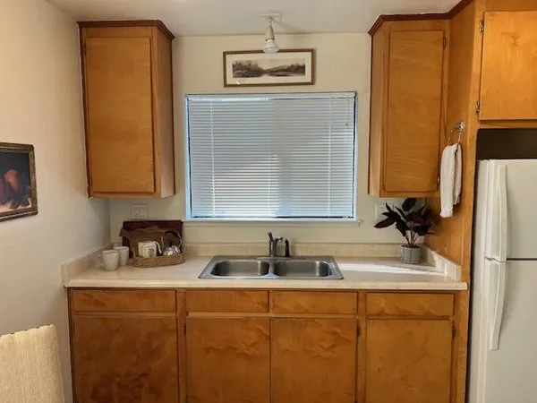 a kitchen with a sink a refrigerator and window
