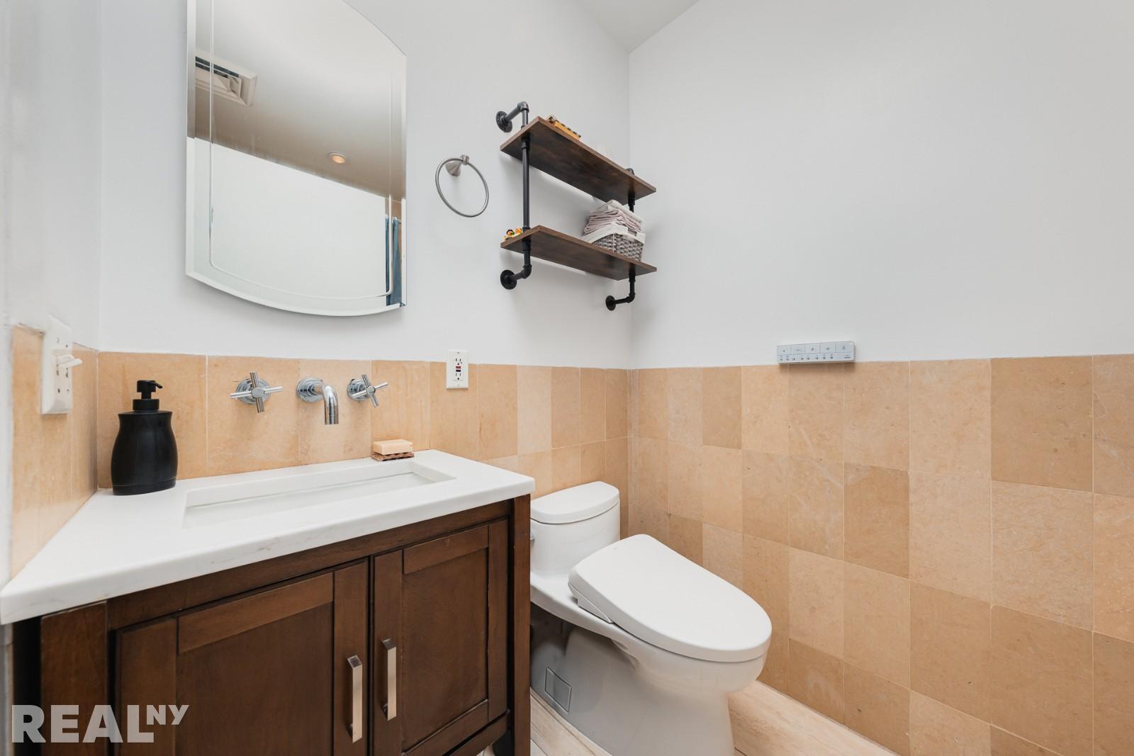 82 Guernsey Street, Unit PH5 Brooklyn, NY 11222 - Photo 8 of 10 a bathroom with a sink a toilet and mirror