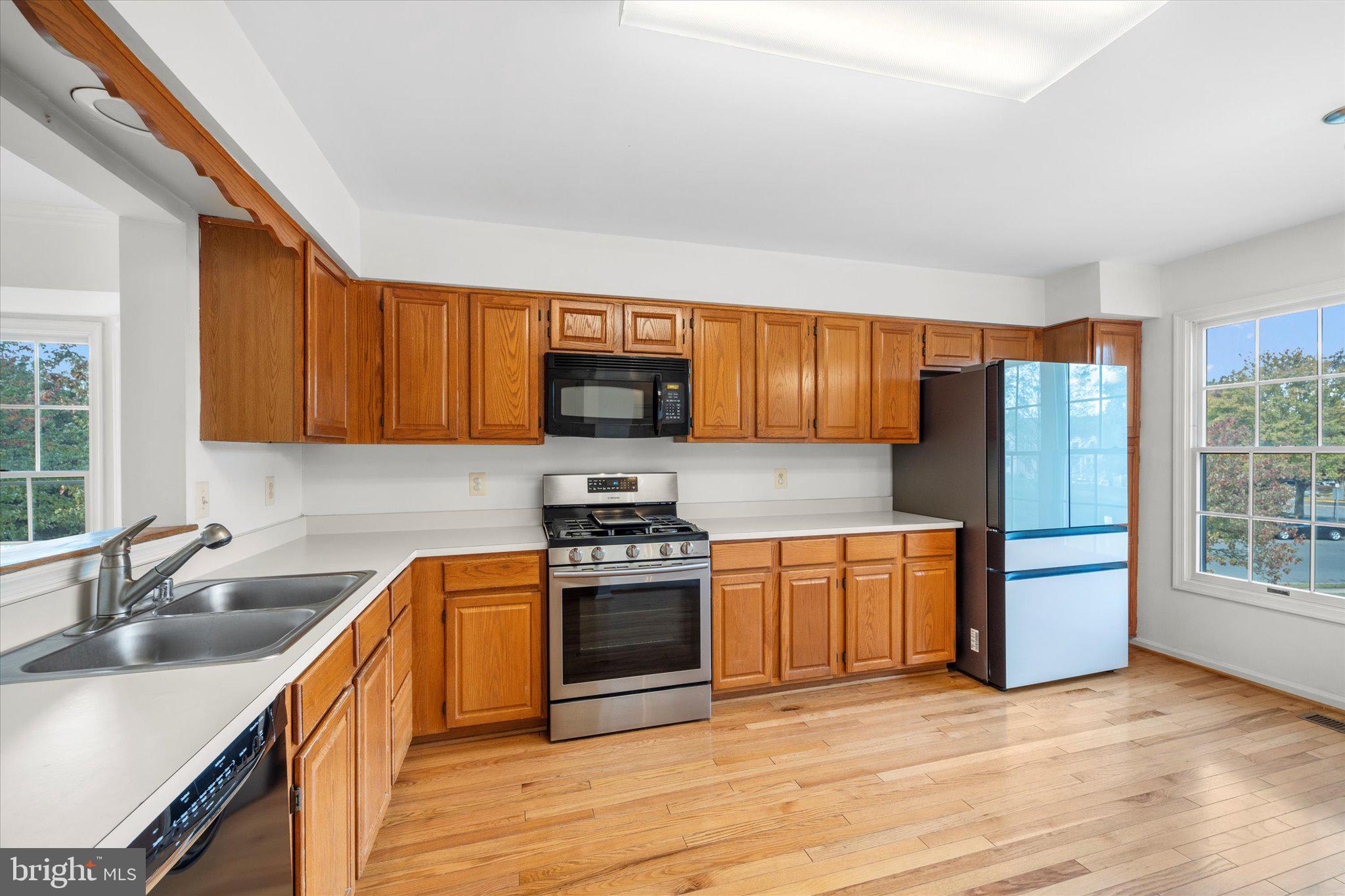 7849 Sabre Court Manassas, VA 20109 - Photo 5 of 35 a kitchen with stainless steel appliances granite countertop a sink stove and refrigerator