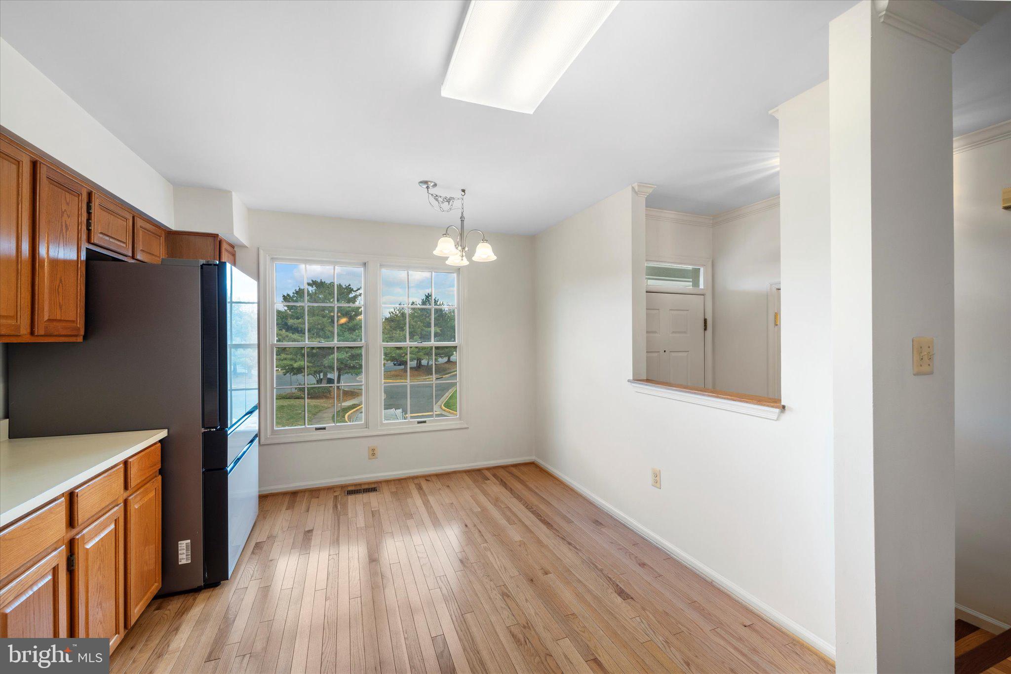 7849 Sabre Court Manassas, VA 20109 - Photo 6 of 35 a view of an empty room with wooden floor and a window