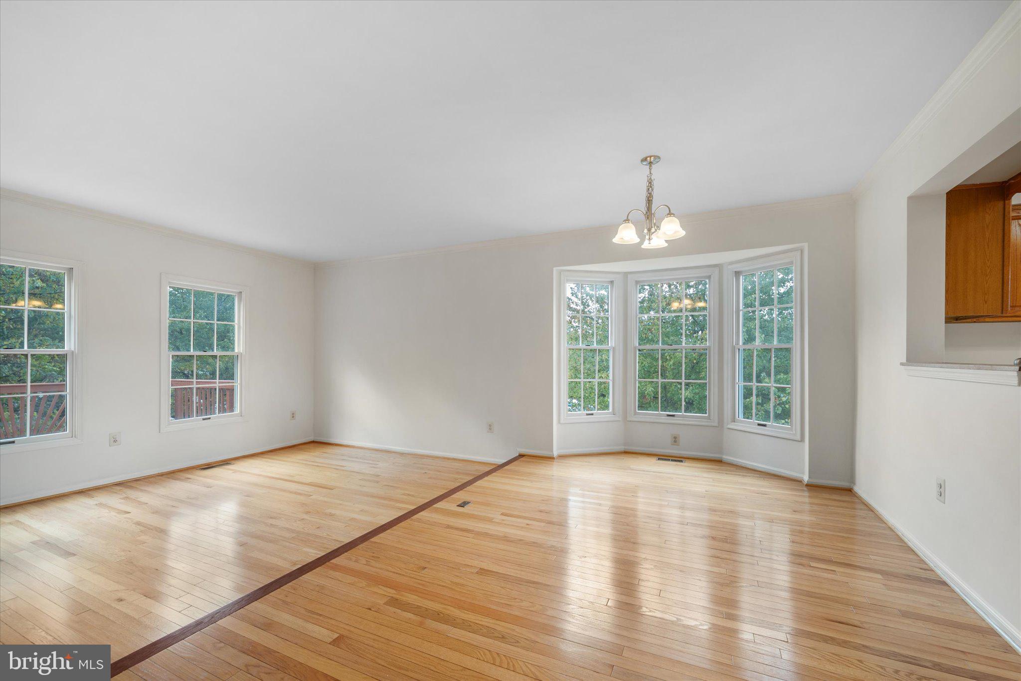 7849 Sabre Court Manassas, VA 20109 - Photo 9 of 35 a view of an empty room with wooden floor and a window