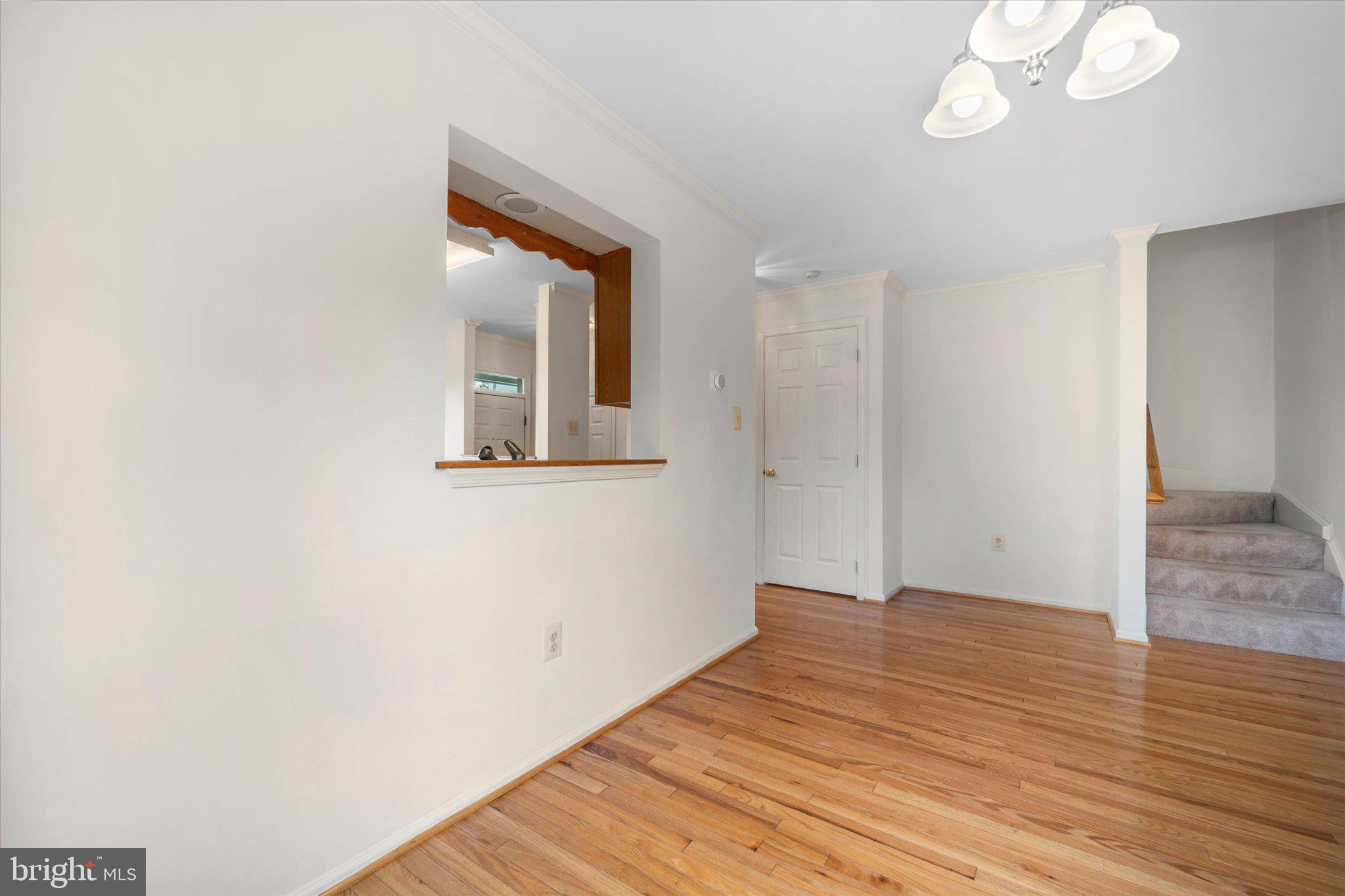 7849 Sabre Court Manassas, VA 20109 - Photo 10 of 35 a view of an empty room with wooden floor and a window