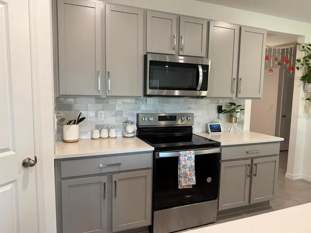 a kitchen with stainless steel appliances granite countertop a sink a stove a microwave and cabinets