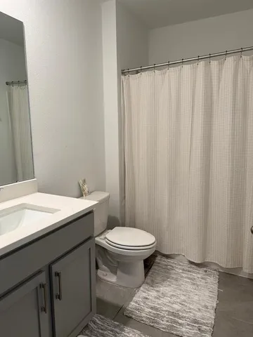 a bathroom with a sink a toilet a window and shower