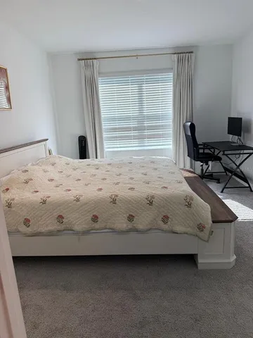 a bed sitting in a bedroom next to a window