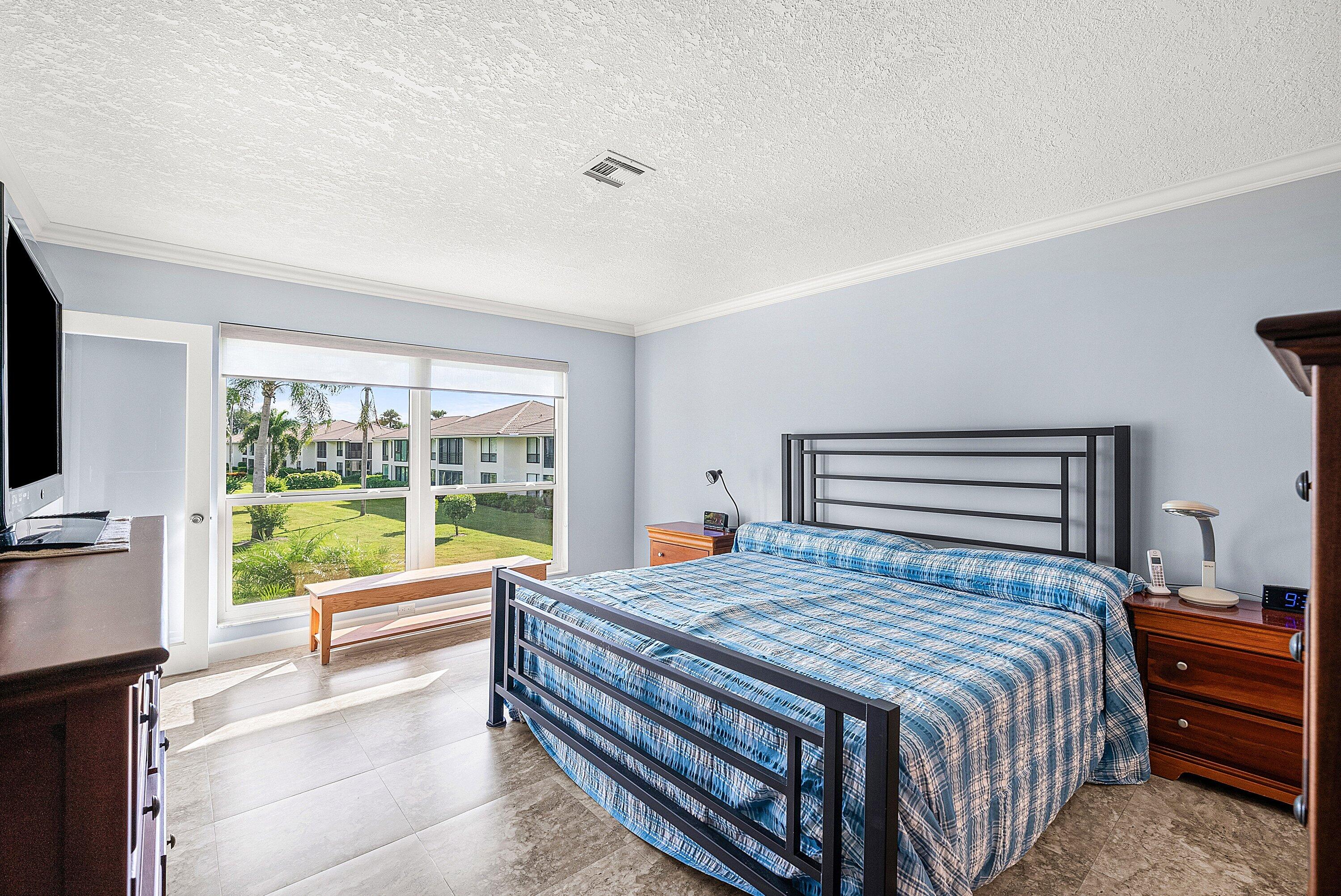 11212 Quail Covey Road, Unit GREEN HERON N Boynton Beach, FL 33436 - Photo 19 of 55 a bedroom with a bed and large windows