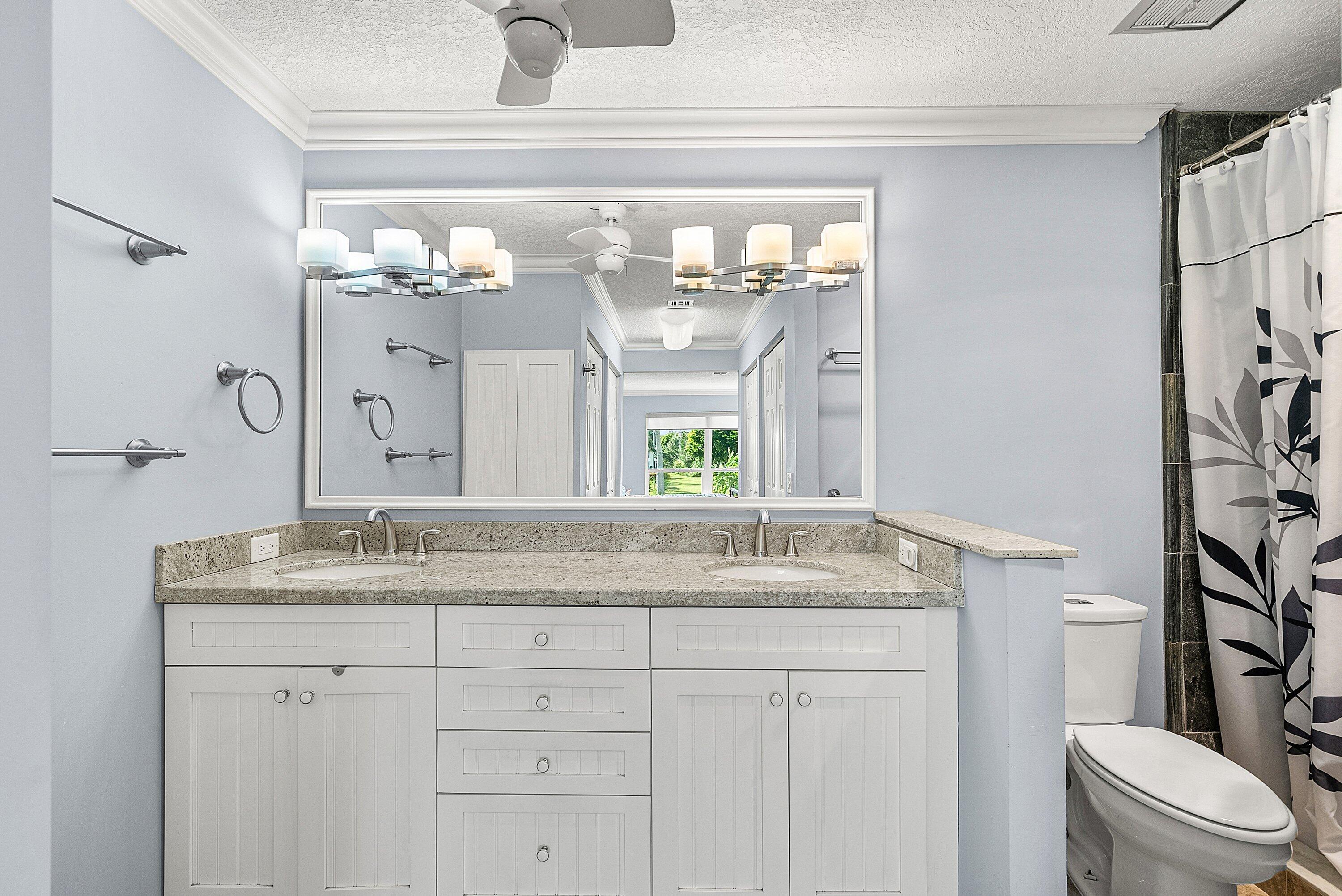 11212 Quail Covey Road, Unit GREEN HERON N Boynton Beach, FL 33436 - Photo 21 of 55 a bathroom with a granite countertop sink a toilet and a mirror