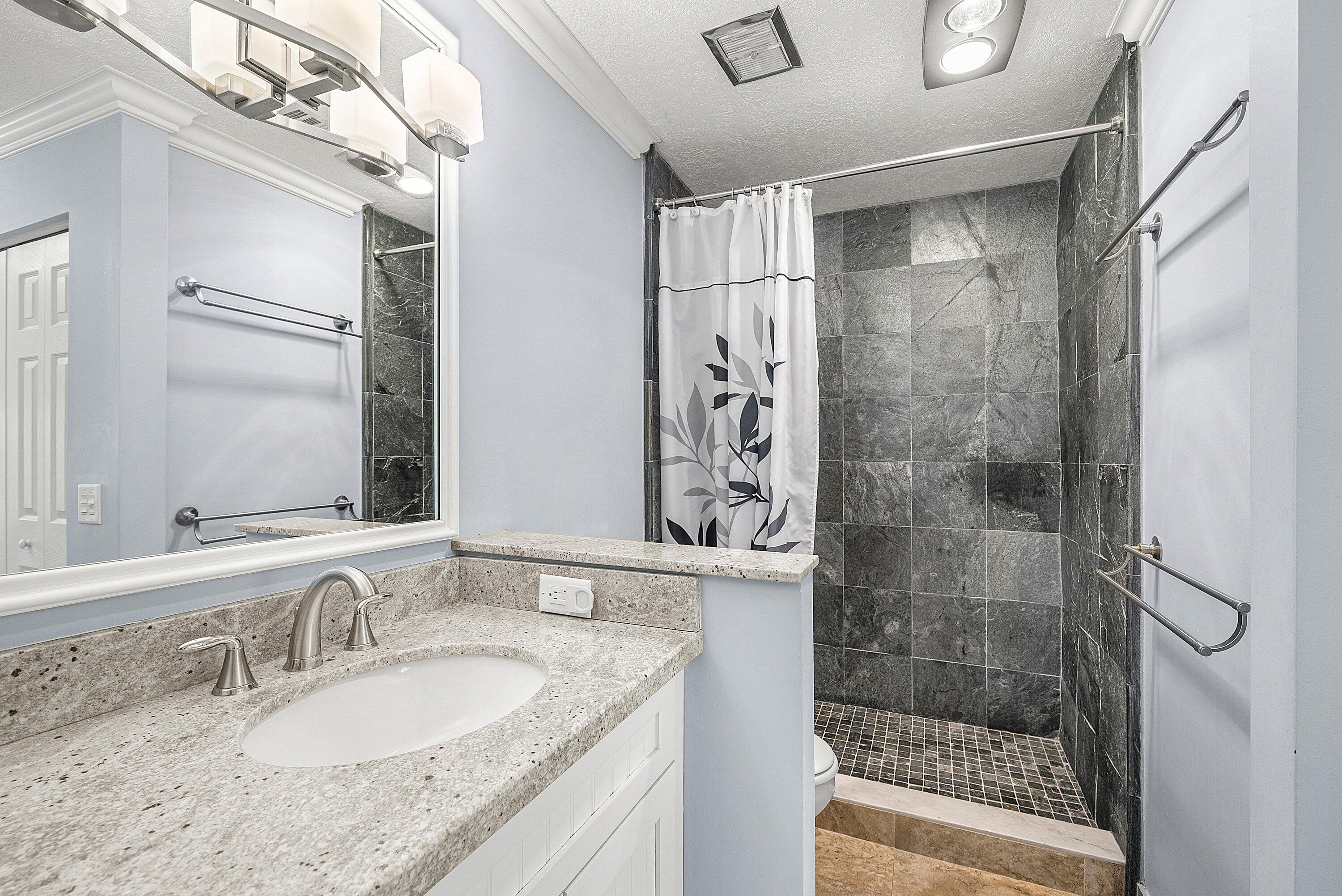 11212 Quail Covey Road, Unit GREEN HERON N Boynton Beach, FL 33436 - Photo 22 of 55 a bathroom with a granite countertop sink a mirror and a shower