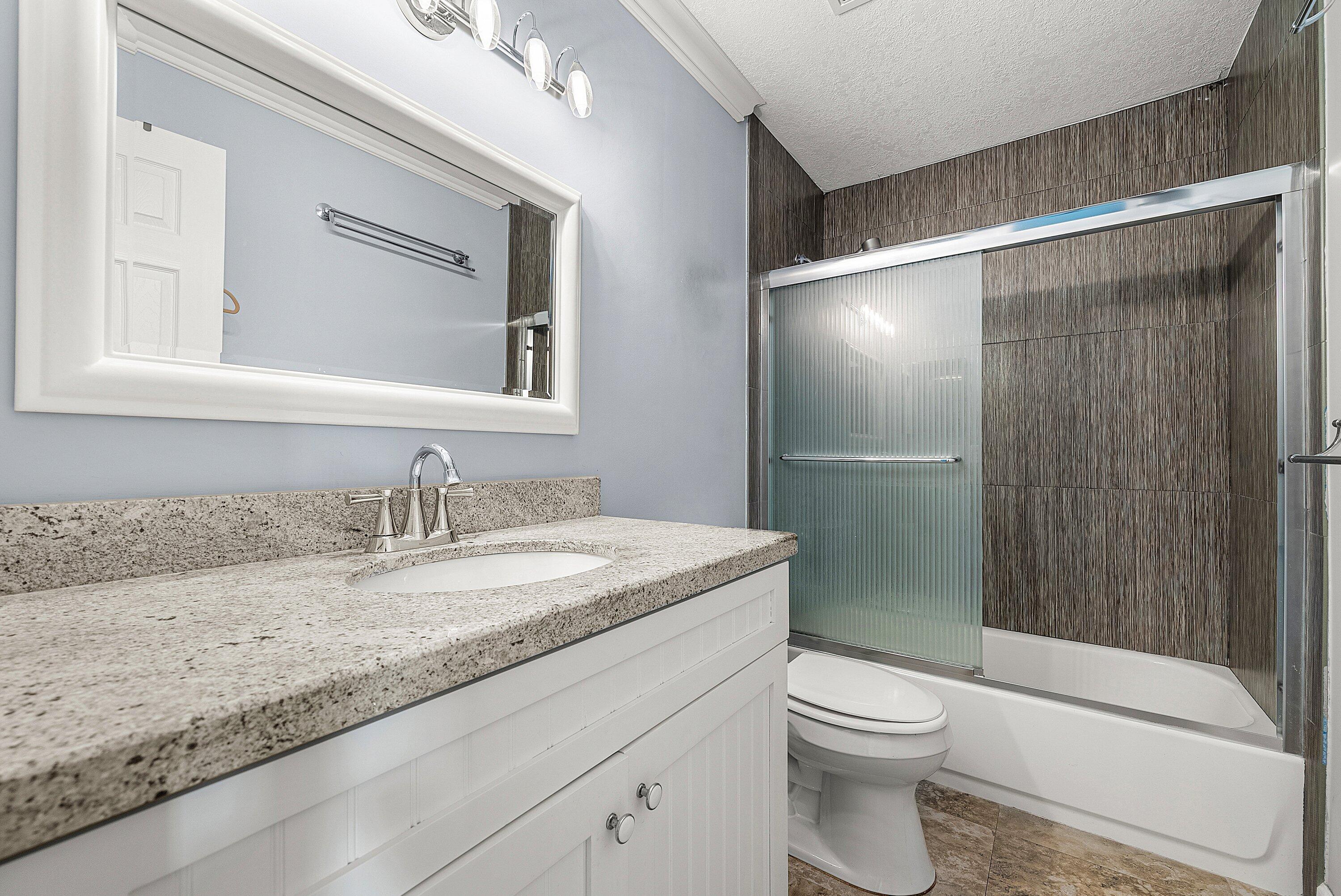 11212 Quail Covey Road, Unit GREEN HERON N Boynton Beach, FL 33436 - Photo 26 of 55 a bathroom with a granite countertop sink toilet and shower