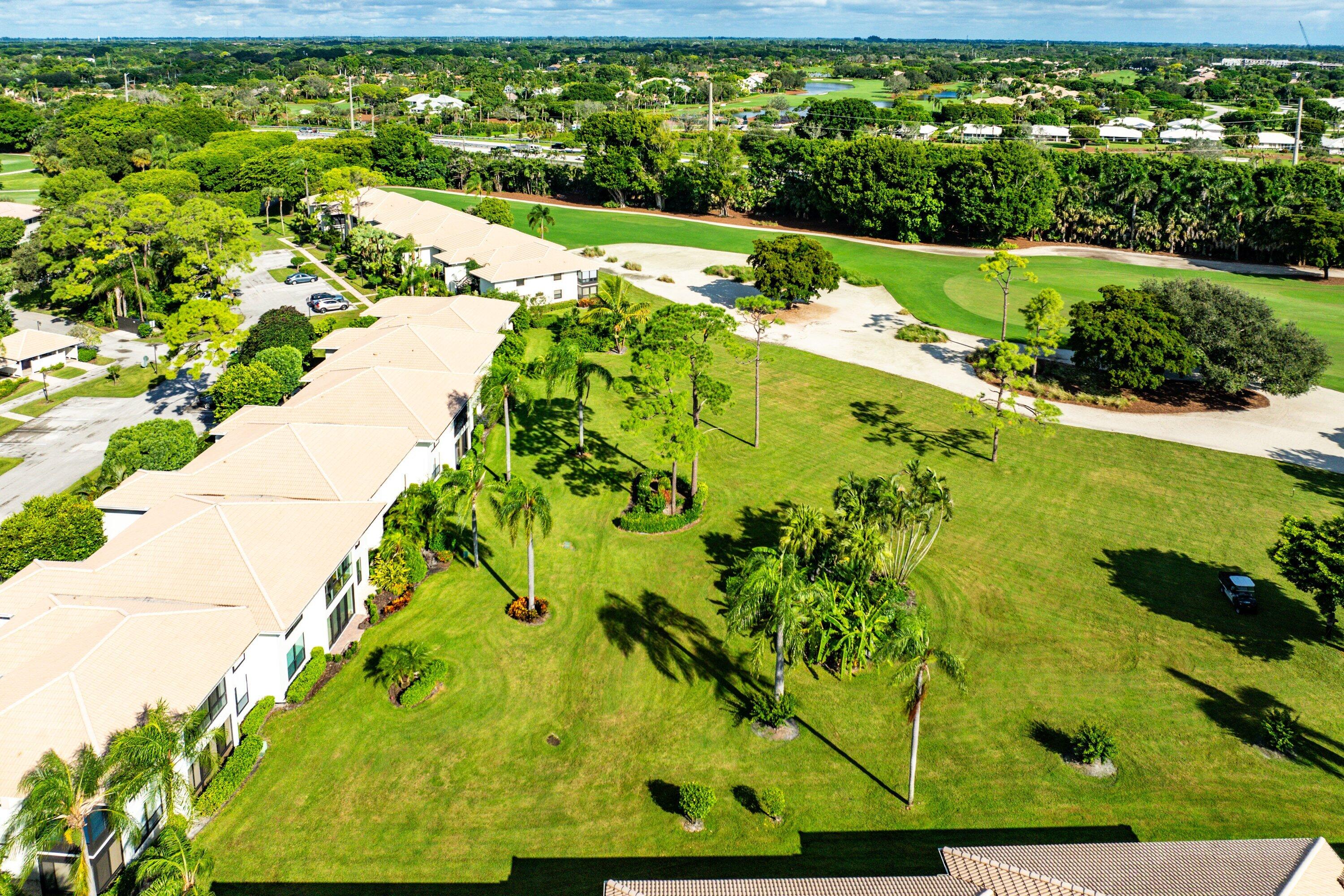 11212 Quail Covey Road, Unit GREEN HERON N Boynton Beach, FL 33436 - Photo 38 of 55 a view of a big yard with table and potted plants