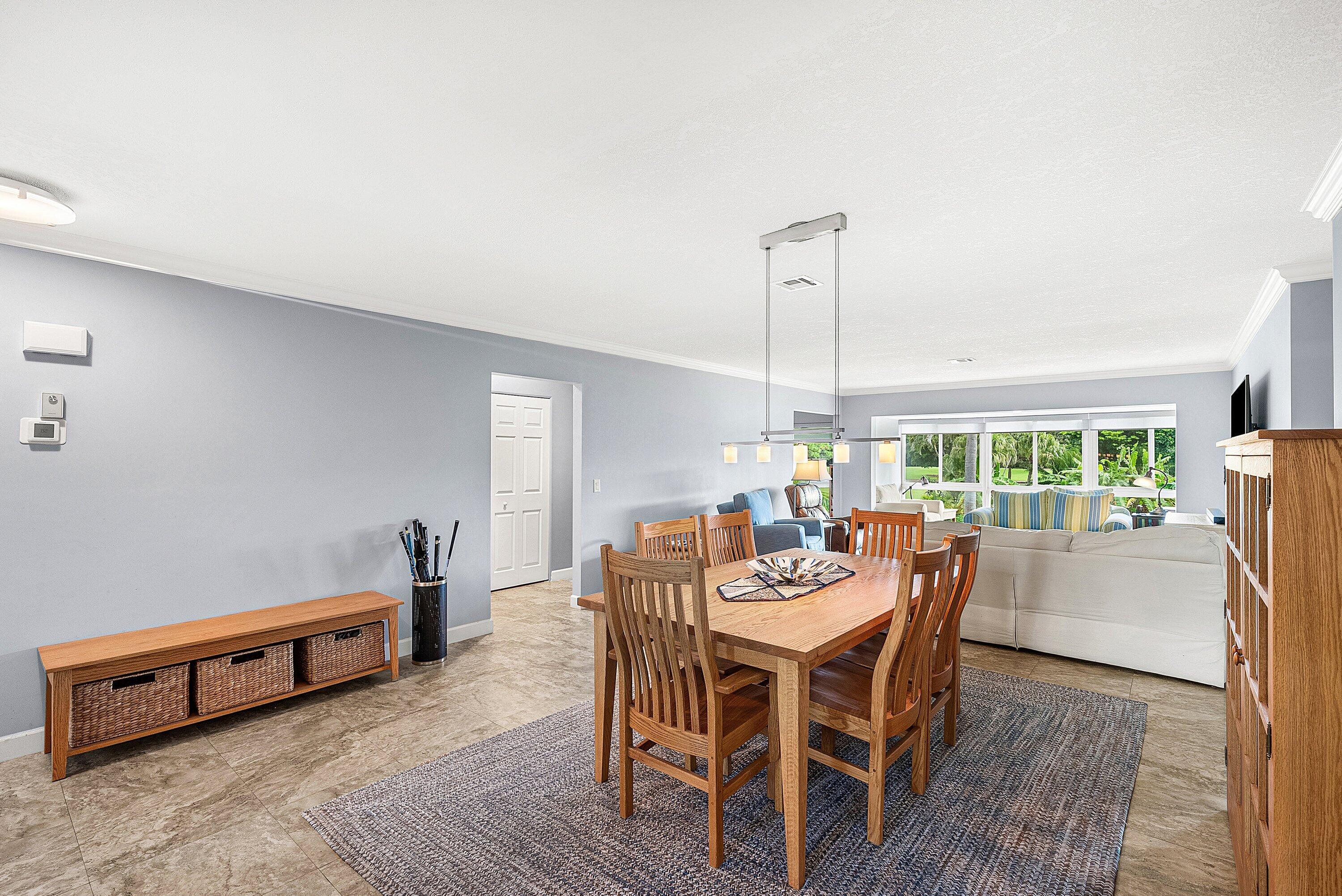 11212 Quail Covey Road, Unit GREEN HERON N Boynton Beach, FL 33436 - Photo 4 of 55 a dining room with furniture a chandelier and wooden floor