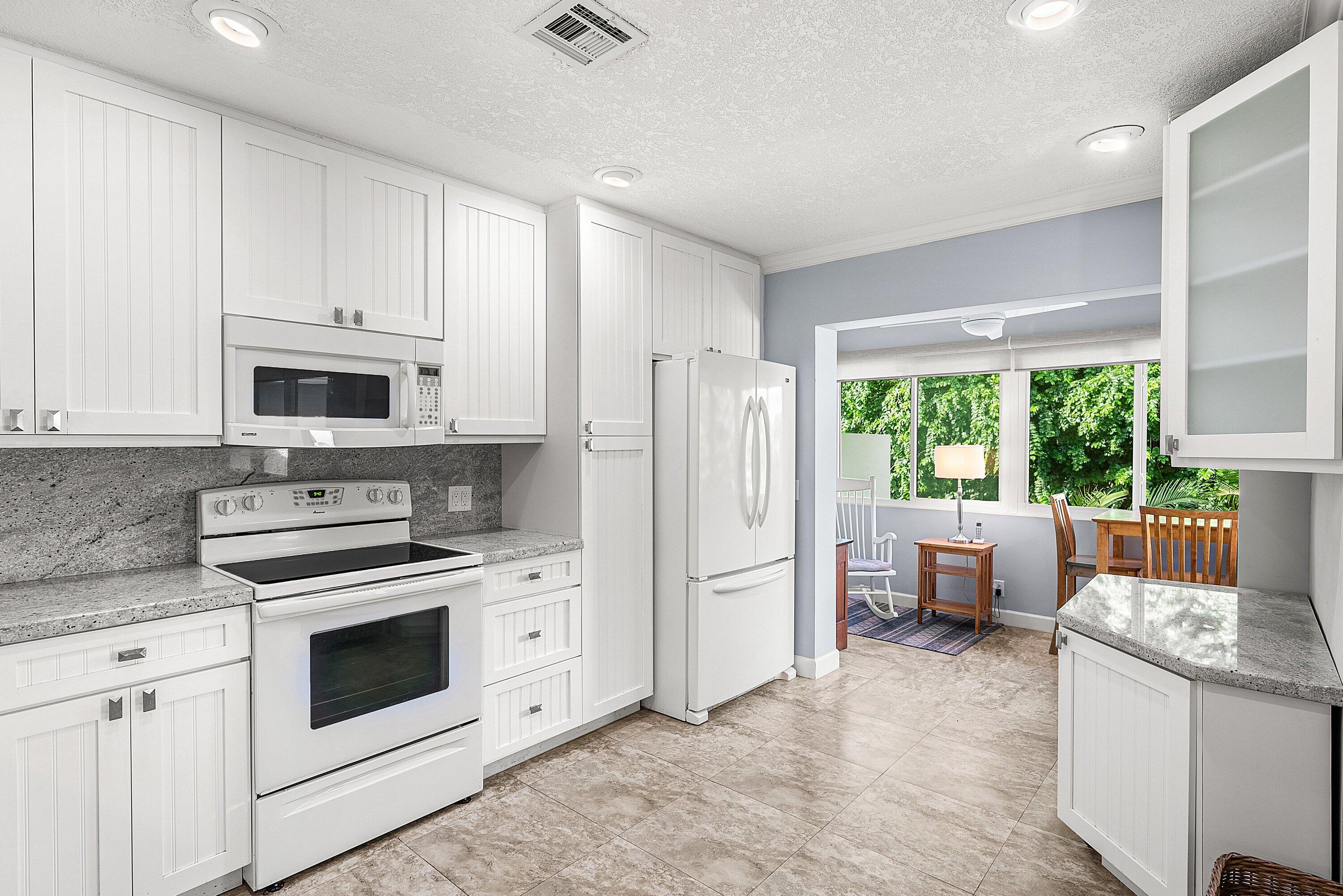 11212 Quail Covey Road, Unit GREEN HERON N Boynton Beach, FL 33436 - Photo 9 of 55 a kitchen with a stove a sink and a refrigerator