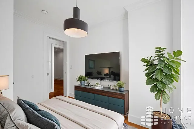 a bedroom with a bed and a potted plant