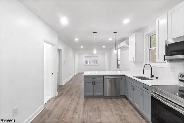 a large kitchen with a sink and dishwasher stove a refrigerator with wooden floor