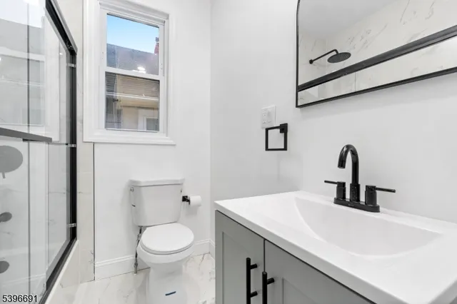 a bathroom with a sink a toilet and a mirror