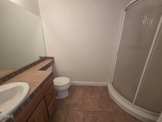 a bathroom with a granite countertop toilet and sink