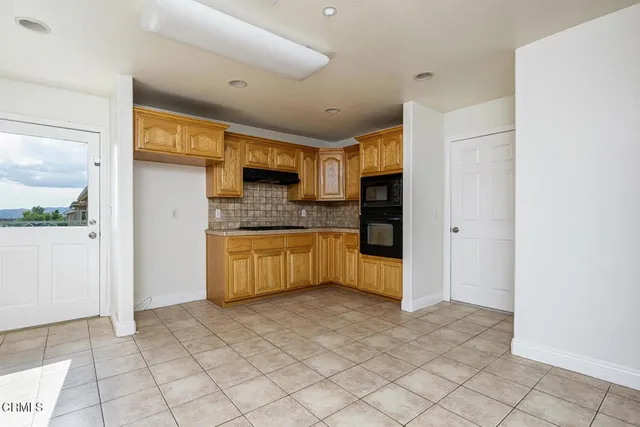 a kitchen with granite countertop a refrigerator and a stove top oven