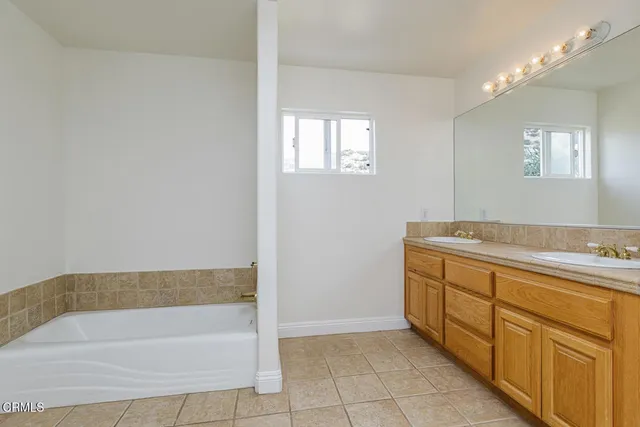 a bathroom with a tub sink and mirror
