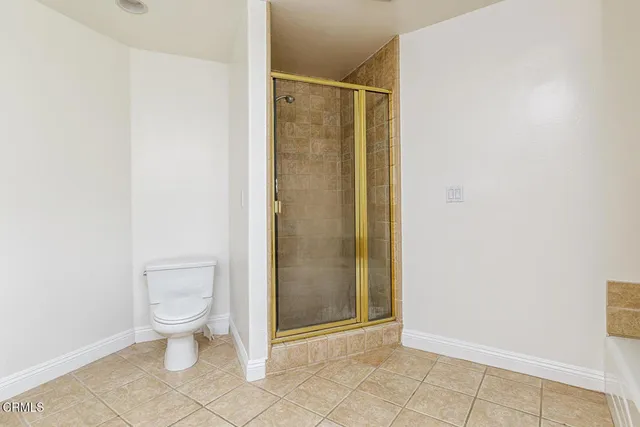 a bathroom with a granite countertop toilet and a shower