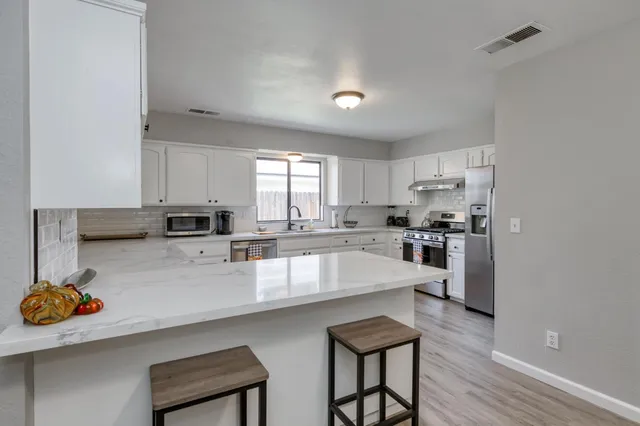 a large kitchen with a large window and stainless steel appliances
