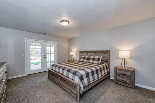 a spacious bedroom with a bed and a lamp